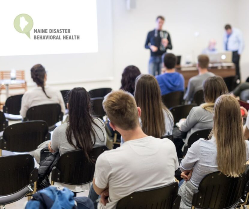 A classroom of college students listen to a speaker.