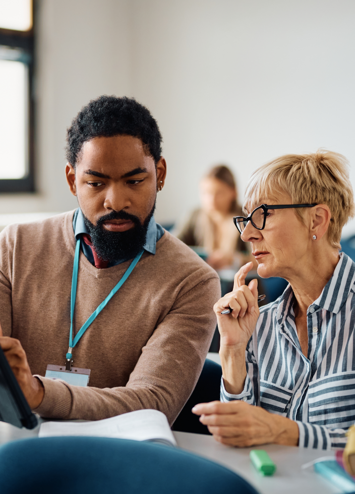 Man and mature woman learning about a training using a tablet